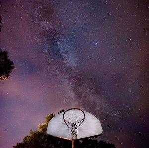 Low angle view of clock tower against star field