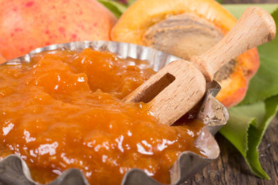 Apricot jam with wooden spoon in plate