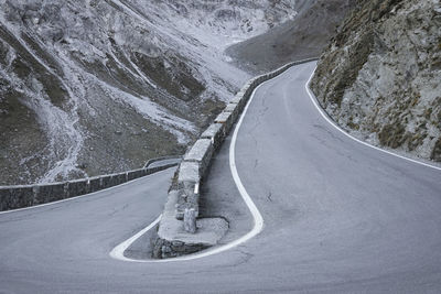 Snow covered road by mountain