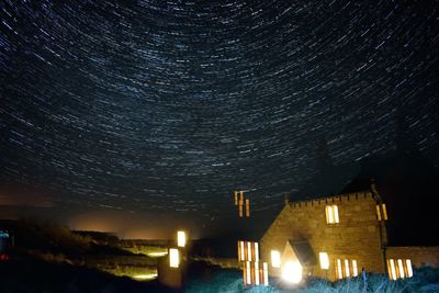 Low angle view of illuminated building against sky at night