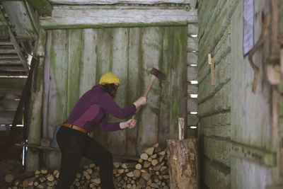 Woman chopping wood in shed