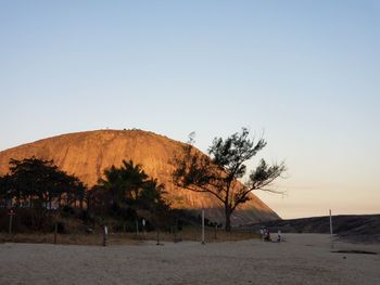 Scenic view of land against clear sky during sunset