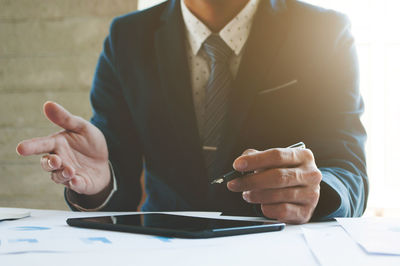 Midsection of businessman gesturing while discussing business strategy in business meeting