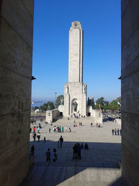 People at temple against clear blue sky