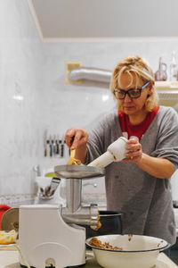 Mature woman preparing food at kitchen