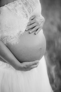 Midsection of pregnant woman standing outdoors