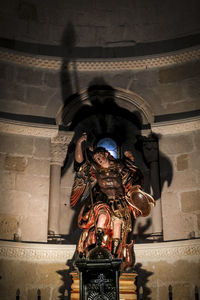 Low angle view of statue against wall