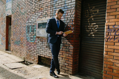 Full length of man standing against wall