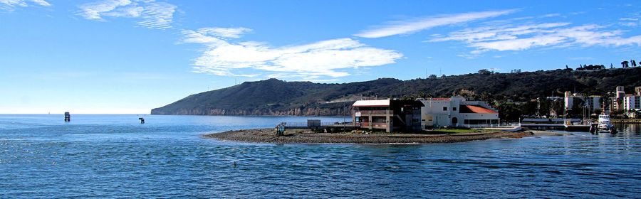 Scenic view of sea by buildings against sky