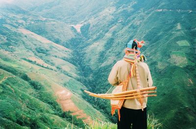 Rear view of woman standing on mountain