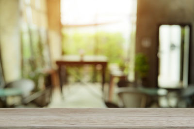 Empty chairs and table against window