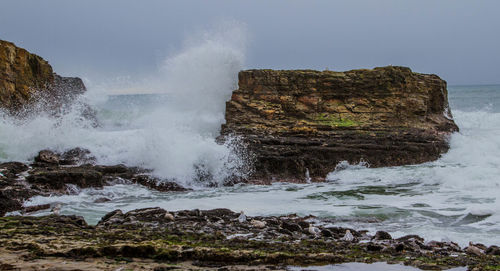 Scenic view of rock formation in sea against sky