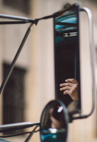 Close-up of hand on mirror against blurred background