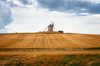 Windmill on field against sky