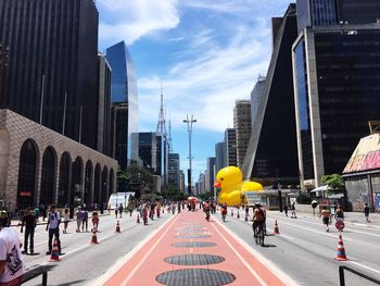 Rubber duck by fiesp building in city against sky