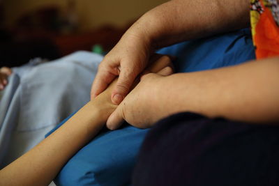 Cropped hand of woman massaging person at hospital
