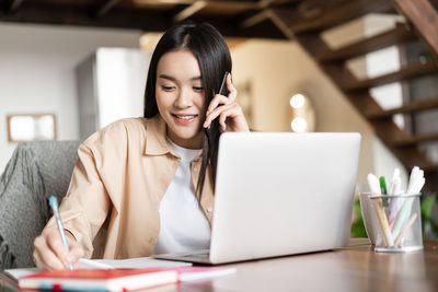 Young woman using laptop at table