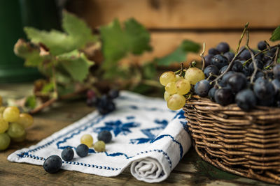 Close-up of grapes in wicker basket on table