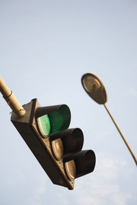 Low angle view of green light against sky