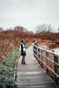 Rear view of man walking on footpath against sky