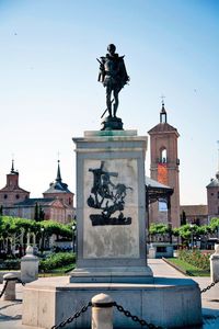 Statue in city against clear sky