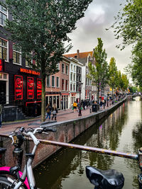 People in canal against buildings in city