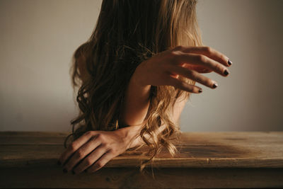 Midsection of woman sitting on wood
