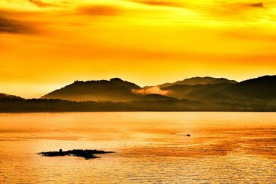 Boats in sea at sunset