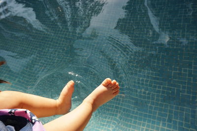 Low section of baby girl over swimming pool