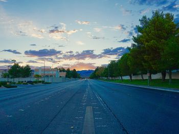 Empty road against cloudy sky