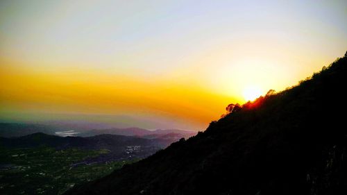 Scenic view of silhouette mountains against sky during sunset
