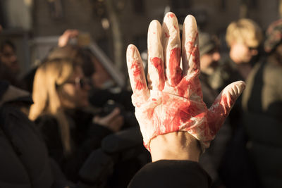 Cropped hand wearing blooded glove