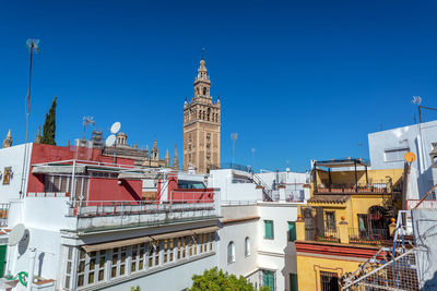 View of buildings in city against blue sky