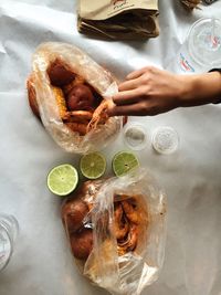 Cropped image of hand having seafood in plastic bags on table