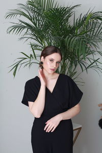 Low angle view of young woman standing against plants