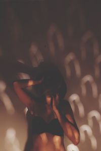 Close-up of young woman standing against blurred background