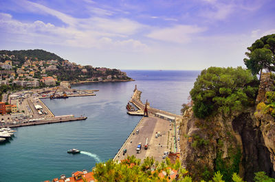 Scenic view of sea by townscape against sky