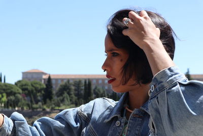 Portrait of woman looking away against sky