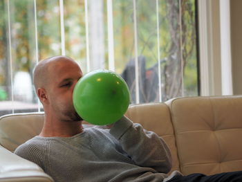 Midsection of man relaxing on sofa at home