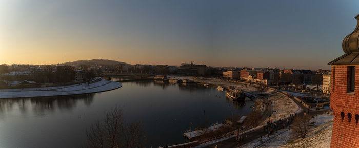 High angle view of river amidst buildings against sky during sunset