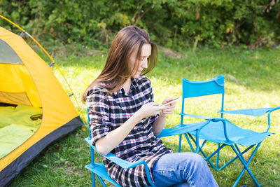 Rear view of woman sitting at tent