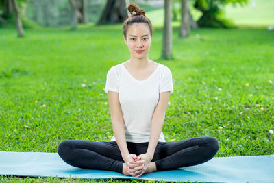 Full length of young woman sitting on grass