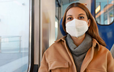 Young woman with kn95 ffp2 face mask looking at camera