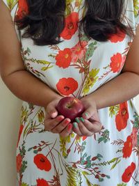 Midsection of woman holding red berries