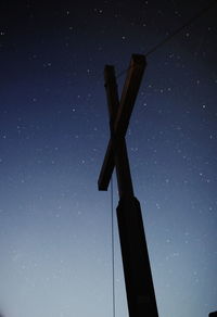 Low angle view of silhouette cross against clear blue sky