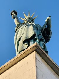 Low angle view of statue against blue sky