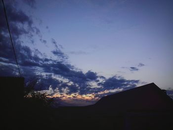 Low angle view of silhouette trees against sky