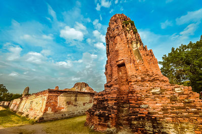 Low angle view of old ruin building against cloudy sky
