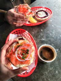 High angle view of hands holding food on table