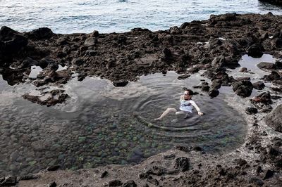 High angle view of man relaxing in water at beach